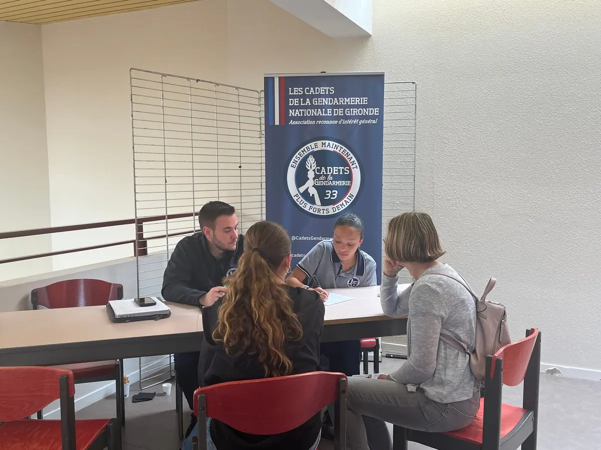 Un cadet et une cadette échangent avec des visiteurs lors d'un accueil